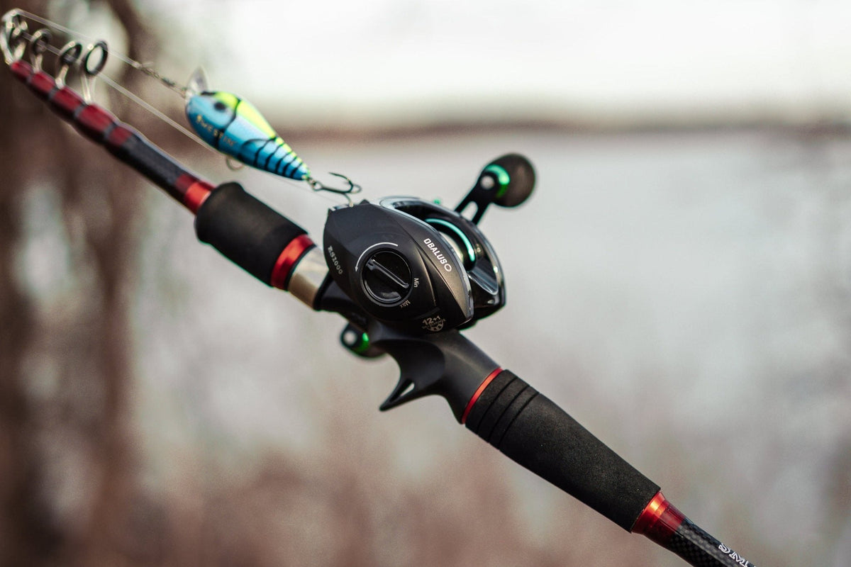 Obalus baitcasting reel on a casting rod with a crankbait, lake in the background