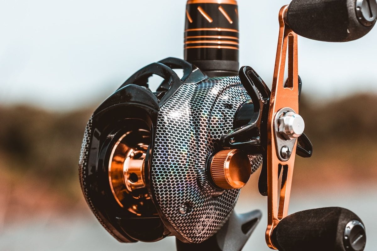 Obalus Cobra Strike baitcasting reel on a rod, showing the handle and side plate