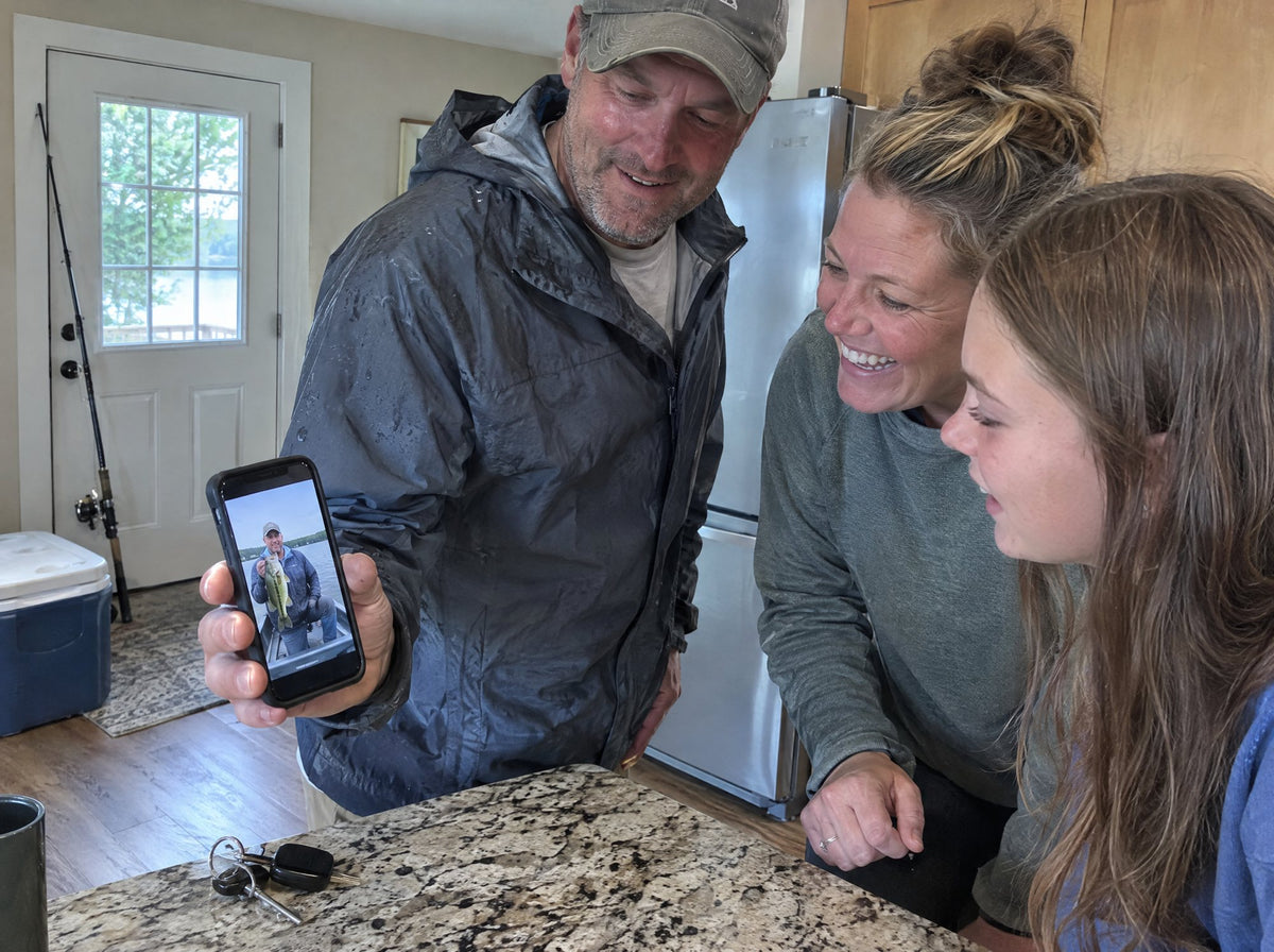 A man showing his family a photo of his catch on his phone