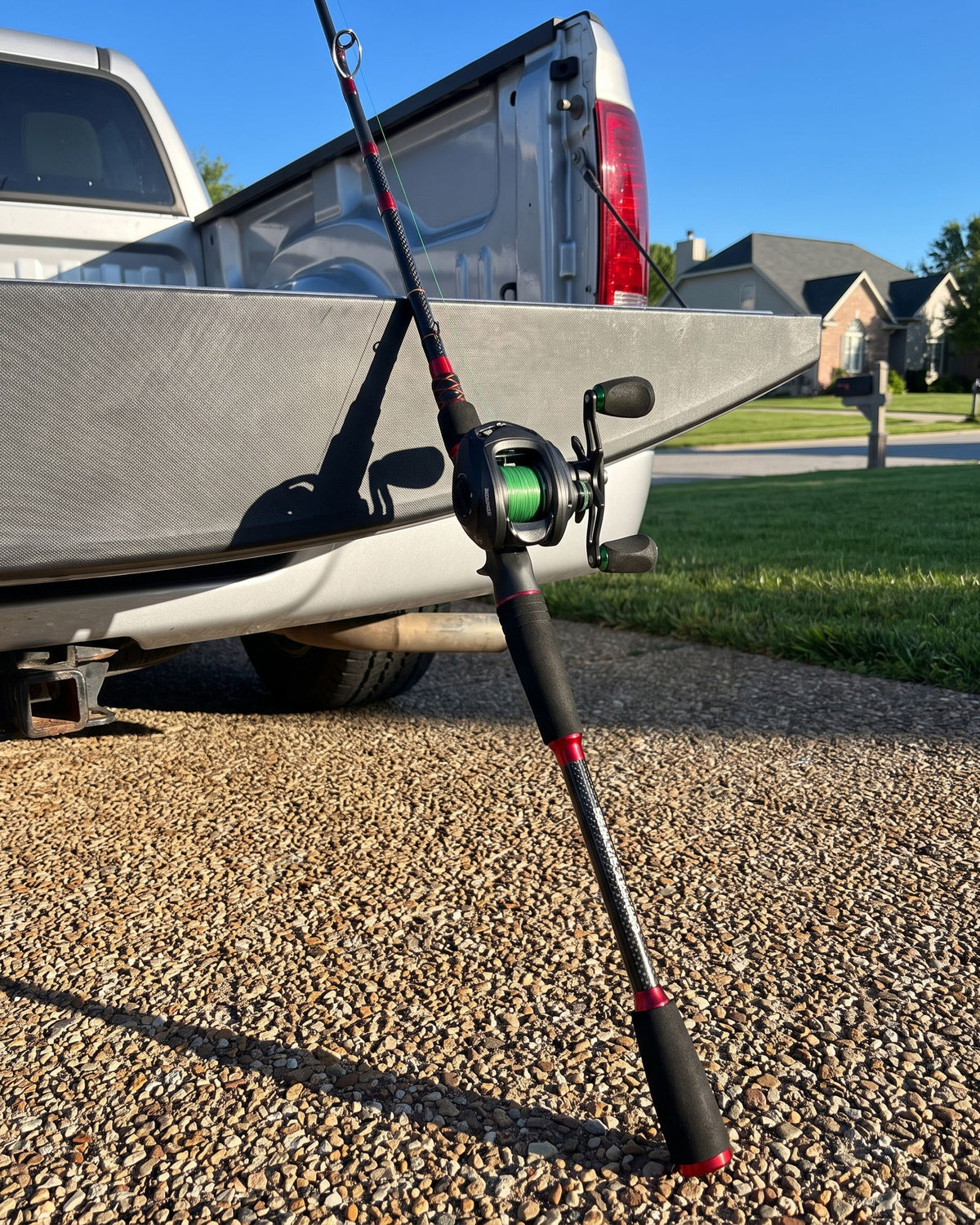 ProFishient casting rod with an Obalus reel leaning against a pickup wheel at a boat ramp