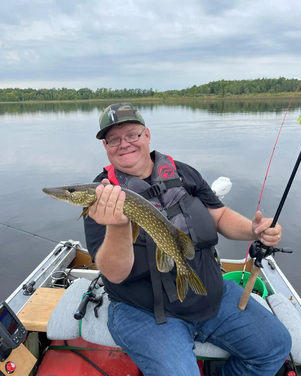 An Obalus owner in his boat holding a northern pike