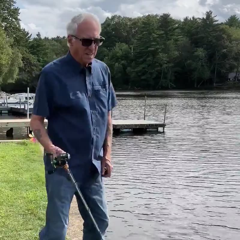 A first-time baitcaster user casting from a lake bank