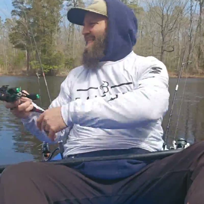 An angler in a boat comparing his name-brand reel with an Obalus reel